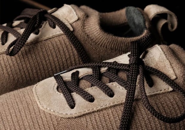 Close-up of brown sneakers featuring textured fabric, suede details, and dark brown laces.